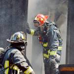 Lt. James Meek, of Central Whidbey Island Fire and Rescue, stands in the doorway of a house on Classic Road destroyed by a fire Wednesday. Photo by Laura Guido/Whidbey News-Times