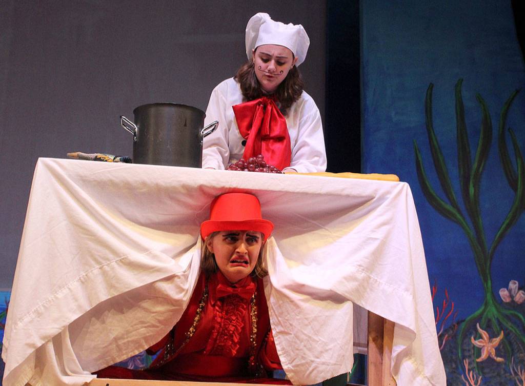 Makenzi Hiatt plays Chef Louis, the knife-wielding cook after shell-shocked Sebastian, who hides under the table. Jessica Turner plays the wise-cracking, comedic crustacean with a lyrical, lilting accent and a wonderful range of expressions. Photo by Patricia Guthrie/Whidbey News Group