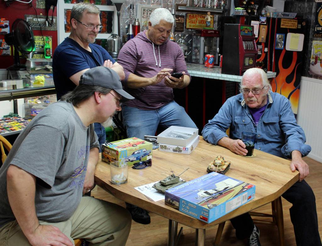 The Friday evening club of small-scale modelers discuss whos building other tiny tanks needed for an upcoming contest. Left to right are Dave Campbell, Roy Schlicht, Ray Scott and Fred Benninghoff.