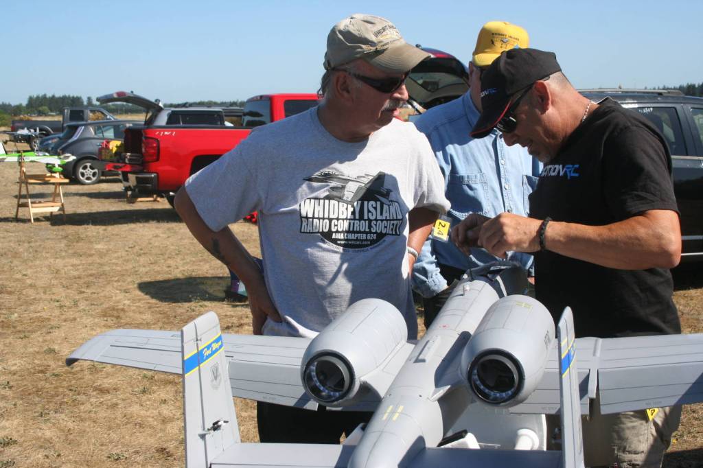 Bill Diekman, vice president of WIRCS, and club member Mark Saia talk as Saia checks one of his model airplanes. Photo by Abigail Gilbert.