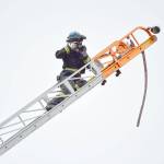 An ATF agent scales a fire engine ladder to get an aerial view of a house that was destroyed in a fire Thursday night in Freeland. Central and South Whidbey fire districts and the sheriffs office are aiding in the investigation. Officials say its too early to know if the origin of the fire is suspicious. Photo by Laura Guido/Whidbey News Group