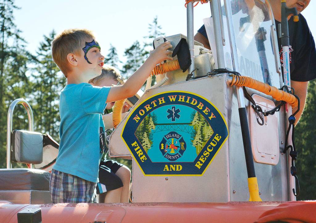 Sawyer Jackson, 4, checks out a North Whidbey Fire and Rescue boat Tuesday night at Fort Nugent during Oak Harbors annual participation in National Night Out. Photo by Laura Guido/Whidbey News-Times