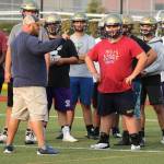 Assistant coach Peter Esvelt discusses a drill with the Oak Harbor lineman Thursday. (Photos by John Fisken)