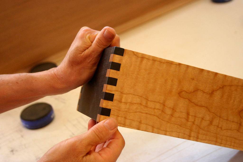 <em>Marian Quarrier holds a drawer that will go into an entertainment center shes making for this years show. She said she likes to use a variety of colors of wood in her pieces and many of her creations feature at least three.</em>