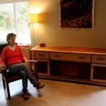 <em>Marian Quarrier sits among some of her creations. The piece that she is working on for this years Woodpalooza will look similar to the long cabinet, although it will be smaller.</em>