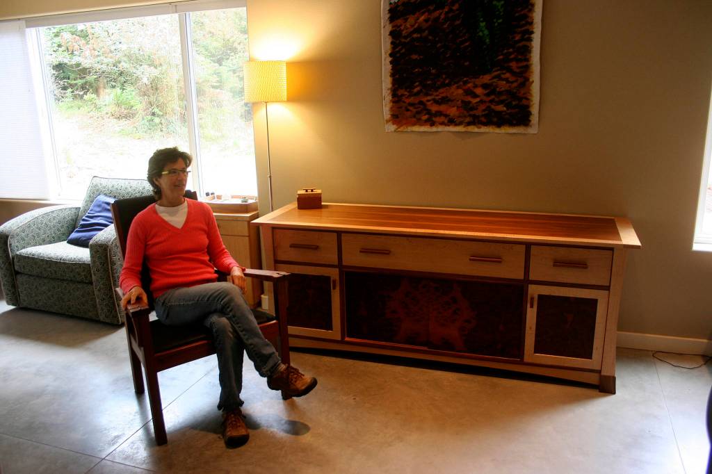 <em>Marian Quarrier sits among some of her creations. The piece that she is working on for this years Woodpalooza will look similar to the long cabinet, although it will be smaller.</em>