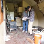 Scott Hornung, left, and Wil Shellenberger, compare their surroundings to a photo from Hornungs childhood. He lived in Navy Homoja housing, which is a program that began during WWII. Researchers from the Naval air museum believe only one remains in the original configuration, and its in need of saving. Photo by Laura Guido/Whidbey News-Times
