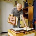 Charley Ryder goes through paintings done by his late wife Helen Ryder. Her art will be featured at a Whidbey Allied Artists show Sept. 21 through 23 at Coupeville Recreation Hall. Photo by Laura Guido/Whidbey News-Times