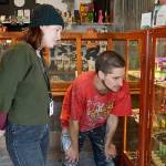 Kelsey Day helps customer Garrett Poling as he examines cannabis oils in a display case at Island Herb. Photo by Laura Guido/Whidbey News Group