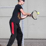 Zach Ginnings swats a backhand in first doubles.(Photo by John Fisken)