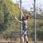 Mason Grove powers a serve during the second doubles match.(Photo by John Fisken)
