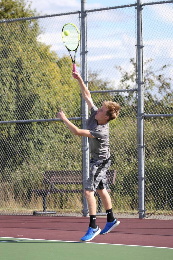 Mason Grove powers a serve during the second doubles match.(Photo by John Fisken)
