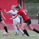 Tia Wurzrainer, right, and Natalie Hollrigel sandwich a Kings player.(Photo by John Fisken)