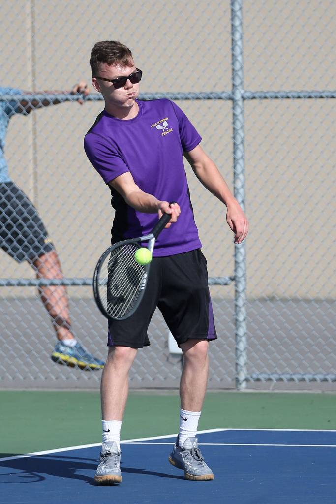Micah Franklin volleys during his win in third singles.(Photo by John Fisken)