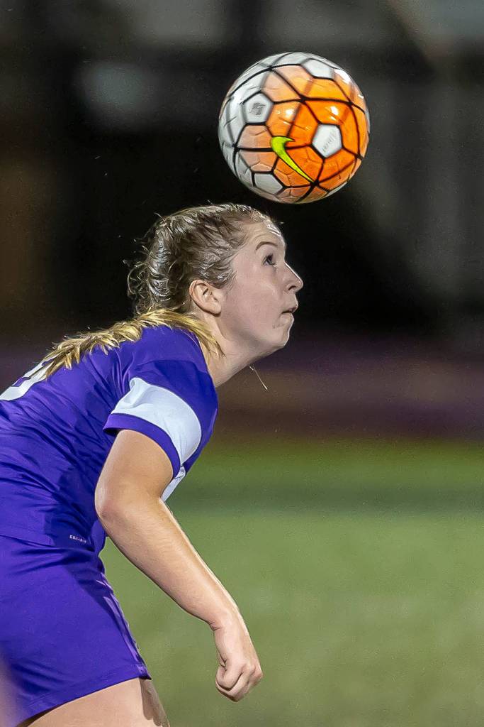 Peyton Rhyne advances the ball with a header for Oak Harbor.(Photo by John Fisken)