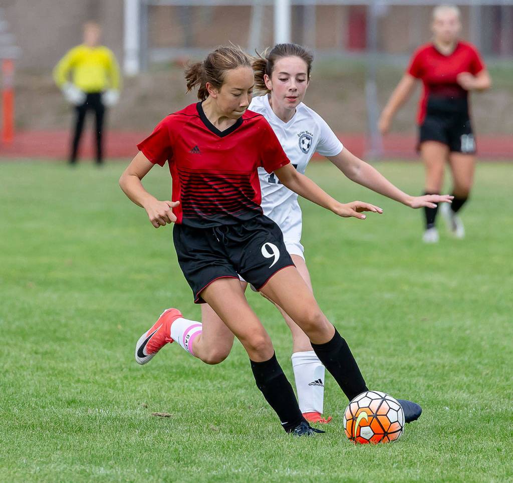 Mary Milnes punches the ball forward for the Wolves.(Photo by John Fisken)