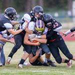 Sean Toomey-Stout (1) and Gavin Knoblich (33) lead a gang of Coupeville tacklers bringing down a Wolverine.(Photo by John Fisken)