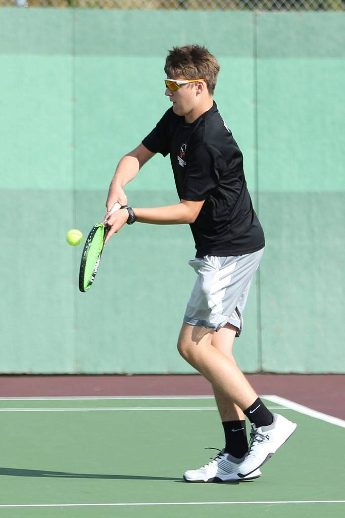 Jacob Burke returns a shot in first doubles.(Photo by John Fisken)