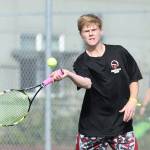 Mason Grove volleys in his win in second doubles.(Photo by John Fisken)