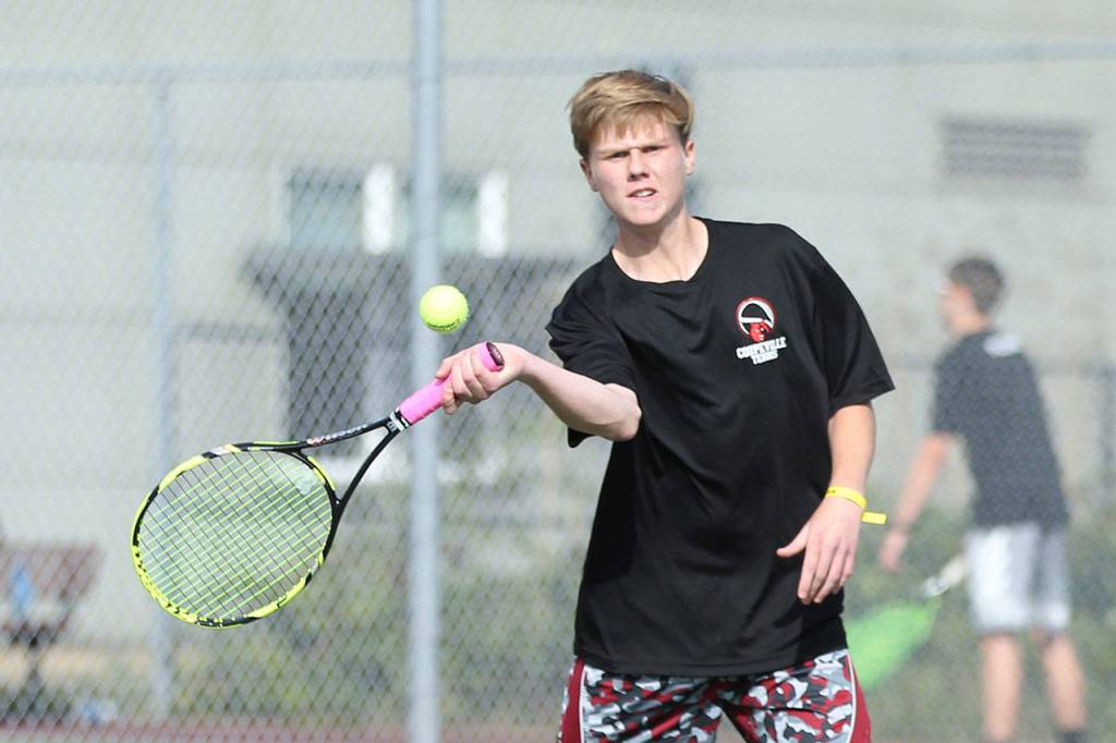 Mason Grove volleys in his win in second doubles.(Photo by John Fisken)