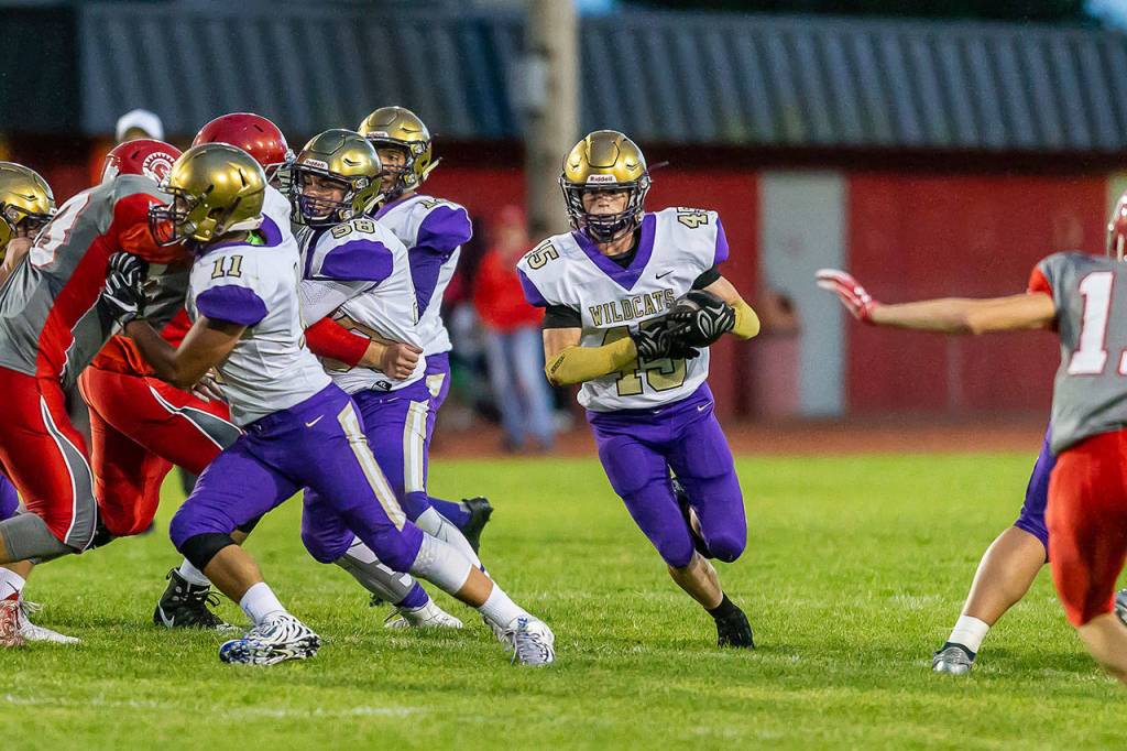 Caden Leckelt (45) runs through a huge hole created by a wall of blockers, including Aaron Martinez (11) and Brandon McCollough (58).(Photo by John Fisken)