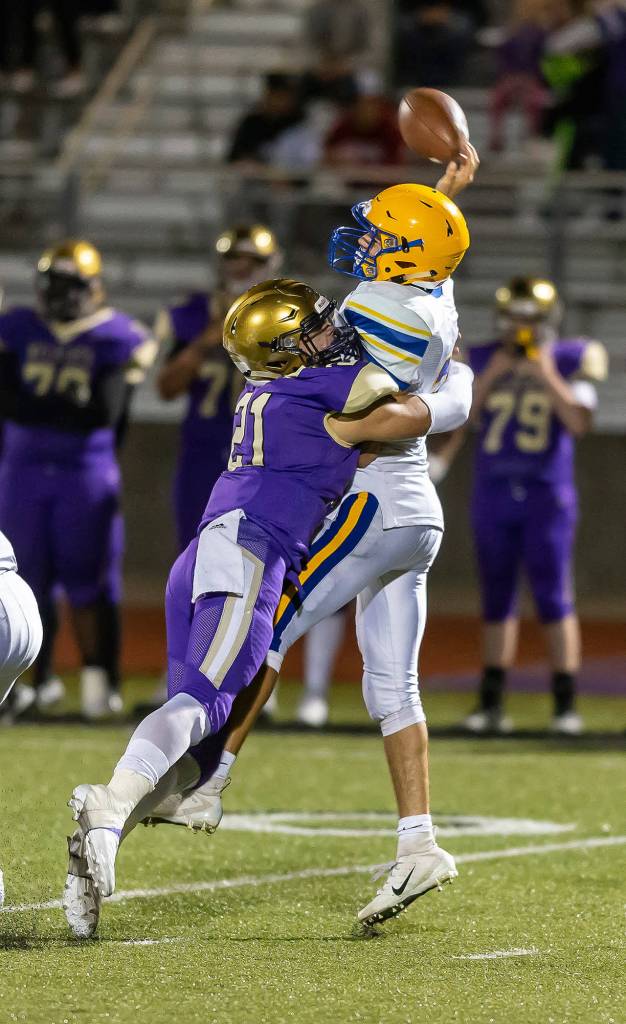 Oak Harbors Calvin Whelpley (21) hits Ferndale quarterback Sequoyah Julius.(Photo by John Fisken)