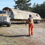 Photo by Laura Guido/Whidbey News-Times                                Cody Robertson directs the truck driver carrying a Quonset hut that PBY Museum Foundation researchers believe is the last remaining one still in its original configuration from WWII Homoja Housing Program.