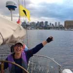 Crew member Kim Kraushar at the helm of Suva leaving the skyline of Seattle behind on the return cruise to Coupeville. The trip took one-and-one-half days each way. (Photo provided)