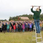 Photo by Jessie Stensland / Whidbey News-Times                                <em>Jen Pennington organizes a card stunt during a rally against Growler jet noise in Central Whidbey Wednesday.</em>