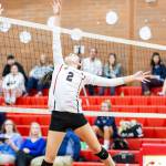 Scout Smith tips a high pass over the net.(Photo by John Fisken)