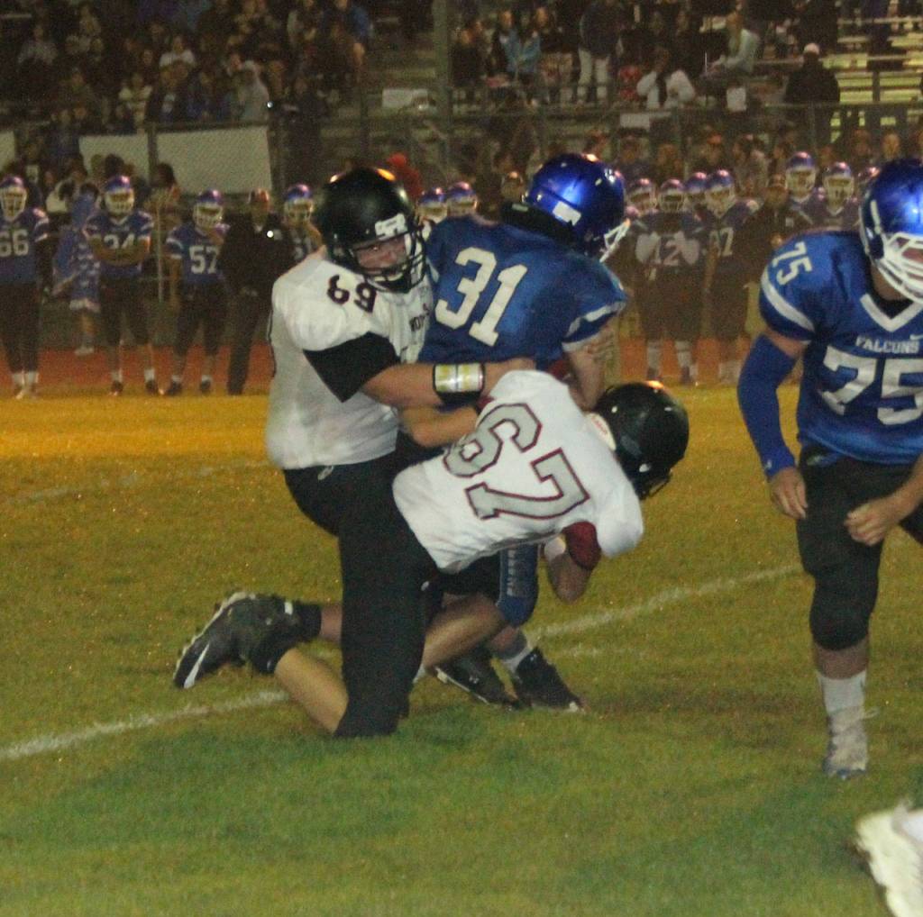 Coupeville defenders Matt Stevens, left, and Gabe Shaw take down South Whidbeys Clay OBrien. (Photo by Jim Waller/Whidbey News-Times)