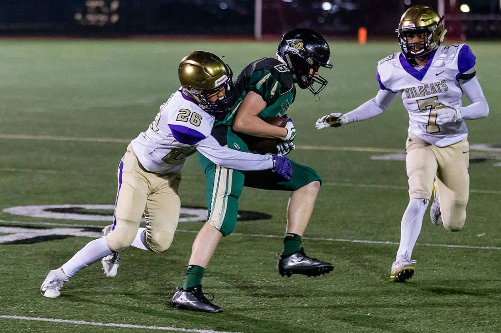 Brenden Andersen (26) tackles Garrett Devereux as Dorian Hardin (7) closes in.(Photo by John Fisken)