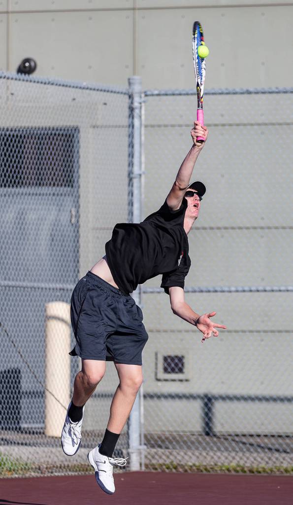 Jakobi Baumann unleashes a serve in first singles.(Photo by John Fisken)