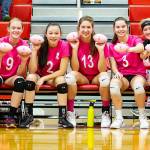 The Coupeville players display the miniature Dig for the Cure footballs they will toss into the crowd during introductions. From the left are Ashley Menges, Chelsea Prescott, Scout Smith, Emma Smith, Maya Toomey-Stout, Emma Mathusek and Hannah Davidson. (Photo by John Fisken)