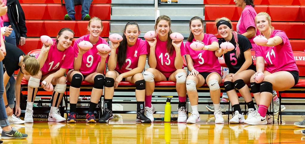 The Coupeville players display the miniature Dig for the Cure footballs they will toss into the crowd during introductions. From the left are Ashley Menges, Chelsea Prescott, Scout Smith, Emma Smith, Maya Toomey-Stout, Emma Mathusek and Hannah Davidson. (Photo by John Fisken)