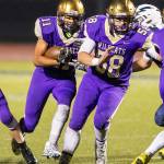 Aaron Martinez (11) runs behind the block of Brandon McCollough (58). (Photo by John Fisken)