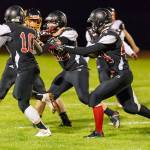 Gavin Straub runs behind the blocks of Shane Losey (10) and Andrew Martin (42).(Photo by John Fisken)