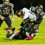 Cam Dahl (18) and Alex Turner (55) bring down Granite Falls Mason McBride (9) as Shane Losey (10) closes in.(Photo by John Fisken)