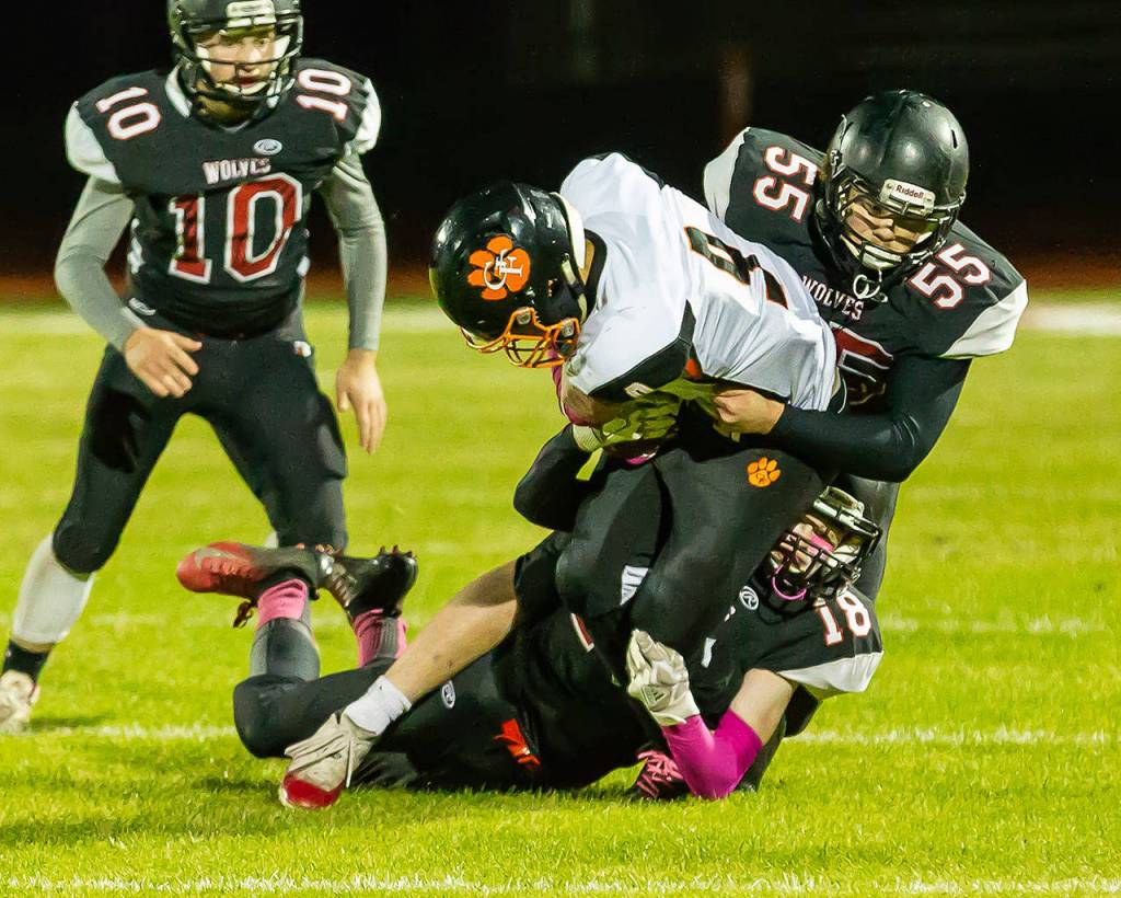 Cam Dahl (18) and Alex Turner (55) bring down Granite Falls Mason McBride (9) as Shane Losey (10) closes in.(Photo by John Fisken)
