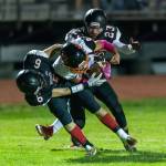 Sean Toomey-Stout (6) and Ben Smith (23) wrestle Mason McBride to the ground.(Photo by John Fisken)