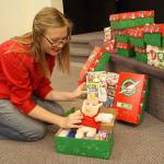 Photo by Maria Matson/Whidbey News Group.                                Drop-Off Coordinater Katelyn Morehead shows one of the many boxes that have already been packed at the Church on the Rock in Oak Harbor.