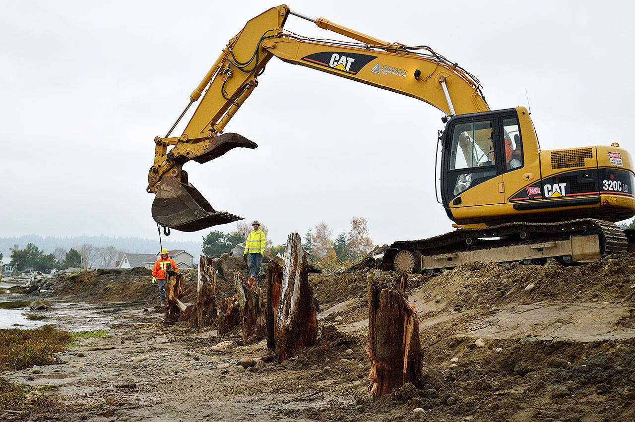 A construction crew works to remove a deteriorating bulkhead at Sunlight Beach in Clinton Thursday morning. The shoreline armor removal is made possible by a partnership between the Island County Marine Resources Committee and the Northwest Straits Foundation. Photo by Laura Guido/Whidbey News Group