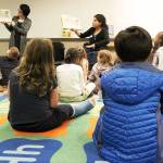 A group of third graders from Oak Harbor Elementary School listen to a story read to them by Mechelle VanHoudt, left, and Claudia Sámano Losada. Photo by Laura Guido/Whidbey News-Times