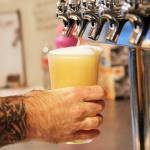 JJ Marti fills up a beer at Rock Island Coffee, which sells much more than just coffee. Photo by Laura Guido/Whidbey News-Times