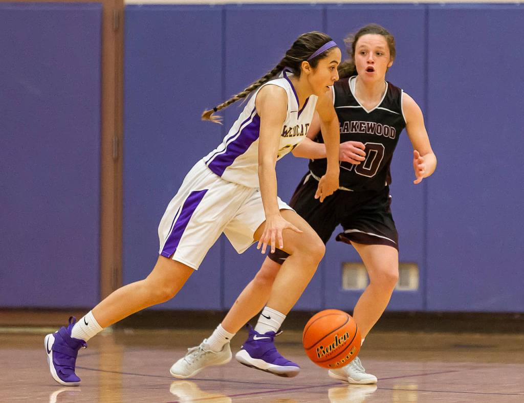 Oak Harbor Mikhaela Cortez dribbles by Lakewoods Riley Mollory. (Photo by John Fisken)