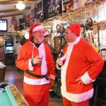 Mike Jackets, left, and Jason Lacey take part in a crucial aspect of the Santa pub crawl tradition. Photo by Laura Guido/Whidbey News-Times
