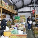 Photo by Maria Matson/Whidbey News-Times.                                Sonya Wallace, left, sorts through canned goods, searching for the best place to put each item. Brad Trimmer, at right, has volunteered at North Whidbey Help House since 2012.