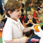 Photo by Laura Guido/Whidbey News-Times.                                Kindergartner Zeddicus Sem receives an orange from Santa during Saint Nicks visit to Oak Harbor Elementary School.