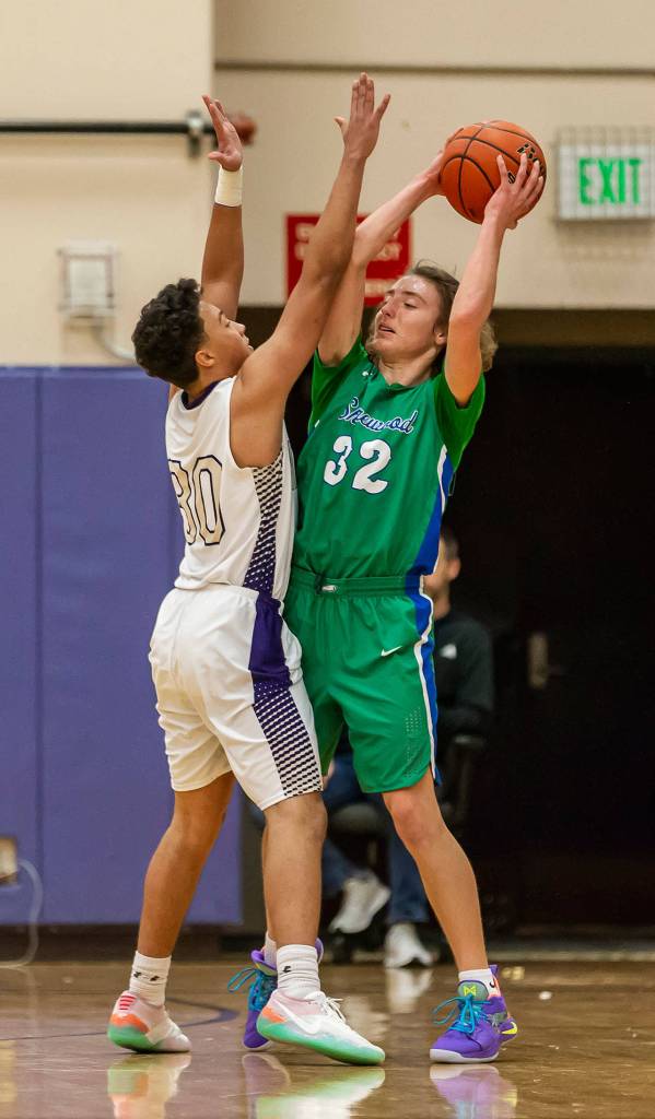 Gavin Allen puts defensive pressure on Shorewoods Spencer Osborn (32). (Photo by John Fisken)
