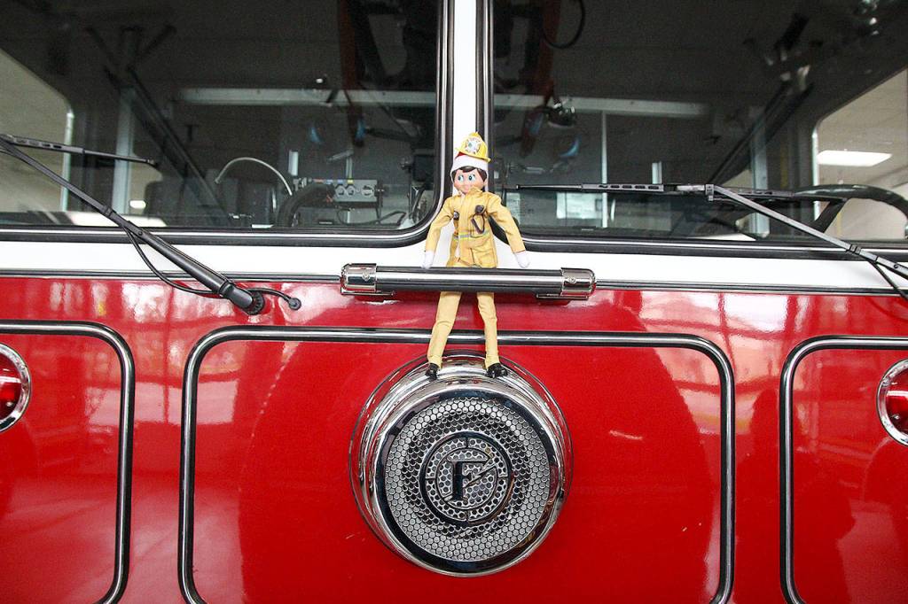Simon the elf hangs out on the nose of an Oak Harbor Fire Department engine. Photo by Laura Guido/Whidbey News-Times